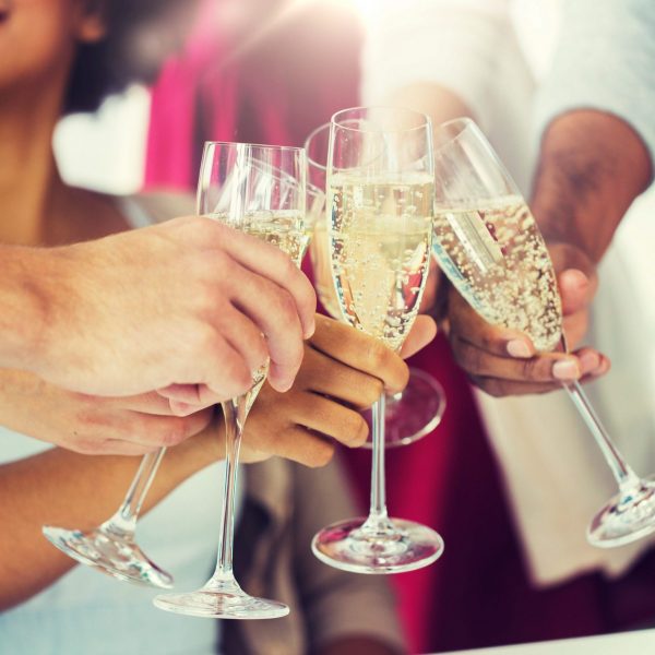 People happily cheers their champagne glasses.